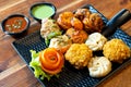 tandoori fried roasted momos dimsum pakora with vegetable flower chicken and green, white and red sauce put in a black Royalty Free Stock Photo