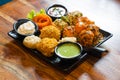 tandoori fried roasted momos dimsum pakora with vegetable flower chicken and green, white and red sauce put in a black Royalty Free Stock Photo