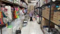 A woman is looking for goods in the aisle of a grocery store