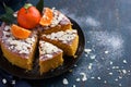 Tangerine and almond cake on dark blue background,