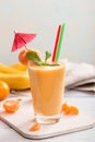 Tangerine and banana smoothie on table