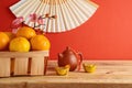 Tangerine in basket for Chinese New Year celebration on wooden table over red background