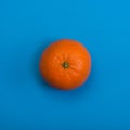 Tangerine on blue background. Top view.