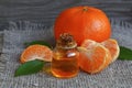 Tangerine essential oil in a glass bottle with fresh mandarin fruit on old wooden table. Royalty Free Stock Photo