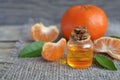 Tangerine essential oil in a glass bottle with fresh mandarin fruit on old wooden table. Royalty Free Stock Photo