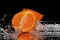 Tangerine splash water on black mirror background