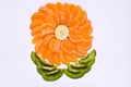 A decorative form in the form of a flower on a white background is made of tangerine and kiwi slices Royalty Free Stock Photo