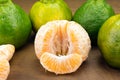 Tangerine variety typical in brazil called ponkan with one peeled isolated in wood background