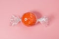 Tangerine wrapped like candy on bright pink background. Royalty Free Stock Photo