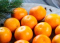 Tangerines bright orange ripe with green leaves on a gray plate with fir branches on the wooden table. table setting for Christmas Royalty Free Stock Photo