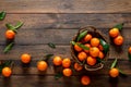 Tangerines fresh mandarin oranges clementines with leaves on wooden background. Top view copy space