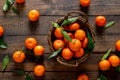 Tangerines fresh mandarin oranges clementines with leaves on wooden background. Top view copy space