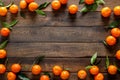 Tangerines fresh mandarin oranges clementines with leaves on wooden background. Top view copy space