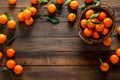 Tangerines fresh mandarin oranges clementines with leaves on wooden background. Top view copy space