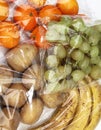 Tangerines, grapes, bananas and potatoes in cellophane bags