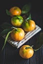 Tangerines with leaves on an old fashioned country table. Selective focus. Vertical.