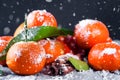 Tangerines with leaves on wooden table.