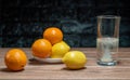 Tangerines and lemons with a glass with vitamin c on a wooden table