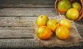 Tangerines mandarins, clementines, citrus fruits with leaves over rustic wooden background.