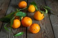 Tangerines (oranges, clementines, citrus fruits) with leaves on a wooden background Royalty Free Stock Photo