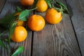 Tangerines (oranges, clementines, citrus fruits) with leaves on a wooden background. Royalty Free Stock Photo