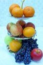 Tangerines, oranges, red and green apples and grapes on a fruit bowl Royalty Free Stock Photo