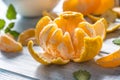 Tangerines with peel and mellisa herbs on table. Ripe fresh tropical fruit on wooden board