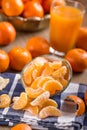 Tangerines, peeled tangerine and tangerine slices on a blue cloth. Mandarine juice