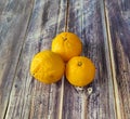 Tangerines. Three whole mandarins close-up on a wooden table