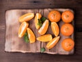 Tangerines whole slices of mint leaves on a cutting Board, an old dark wooden table,close-up with