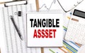 TANGIBLE ASSETS text on notebook with chart, calculator and pen Royalty Free Stock Photo
