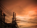 Tangle cable and electricity post on sunset background. Royalty Free Stock Photo