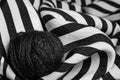 Tangle of knitted thread on striped fabric, black and white photo