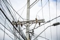 Tangle of wires and cables on a pole against the clear sky Royalty Free Stock Photo