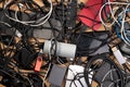 Tangled cables, hard drives and other electronic equipment on wooden desk