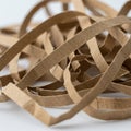 Tangled strips of brown corrugated cardboard sit in a heap on a flat surface. The strip Royalty Free Stock Photo