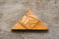 Tangram puzzle in trianle shape on wood background