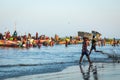 TANJI, THE GAMBIA - NOVEMBER 21, 2019: People carrying fish from the boats to the beach on Tanji, Gambia, West Africa Royalty Free Stock Photo