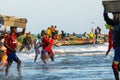 TANJI, THE GAMBIA - NOVEMBER 21, 2019: People carrying fish from the boats to the beach on Tanji, Gambia, West Africa Royalty Free Stock Photo