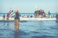 TANJI, THE GAMBIA - NOVEMBER 21, 2019: People carrying fish from the boats to the beach on Tanji, Gambia, West Africa Royalty Free Stock Photo
