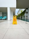 Sign of a wet floor by the pool.