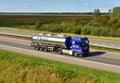 Tank truck MAN driving on highway. `B.S.A.T.` specifics of the truck transportation of liquid goods. Metal chrome cistern tanker