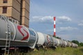 Tank wagons train from Nafta Industria Srbije passing near a factory chimney in an industrial district of capital city of Serbia