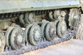 Tank wheels close-up. Iron tracks of a heavy military tank. Iron caterpillars and wheels of a military heavy tank. View of the