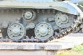 Tank wheels close-up. Iron tracks of a heavy military tank. Iron caterpillars and wheels of a military heavy tank. View of the