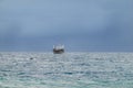 Tanker ship alone on a rough ocean with a cloudy storm sky in the background Royalty Free Stock Photo