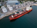 Tanker ship refueling at an oil terminal with storage silo's in the port, aerial view Royalty Free Stock Photo