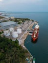 Tanker ship refueling at an oil terminal with storage silo's in the port, aerial view Royalty Free Stock Photo