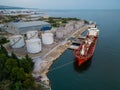 Tanker ship refueling at an oil terminal with storage silo's in the port, aerial view Royalty Free Stock Photo