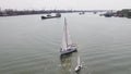 Tanker ship and sailboat on river. Aerial view. Sailboats and a tanker